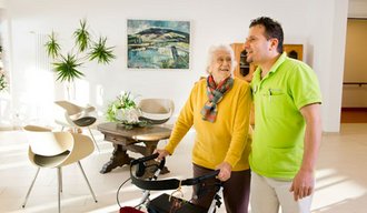 Eine Seniorin und ein Mitarbeiter der AllgäuPflege