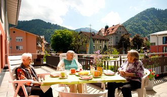 Senioren sitzen am Tisch der Stationären Eirichtung der AllgäuPflege in Immenstadt